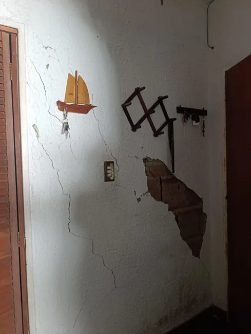 Pared interior con fisuras y desprendimiento de revestimiento