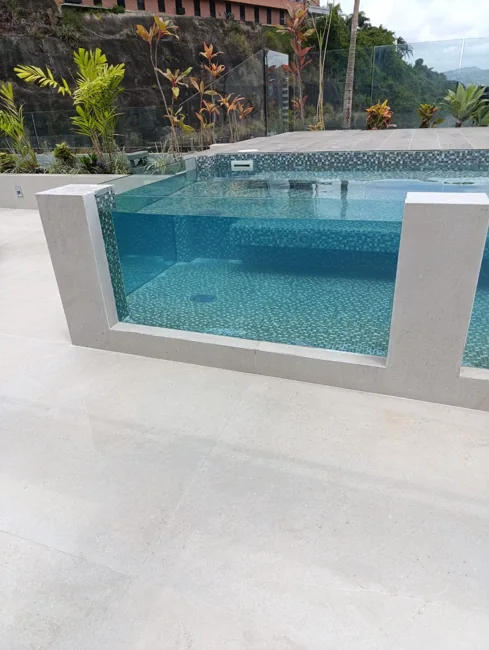 Vista de piscina con revestimiento de mosaico y frente de vidrio