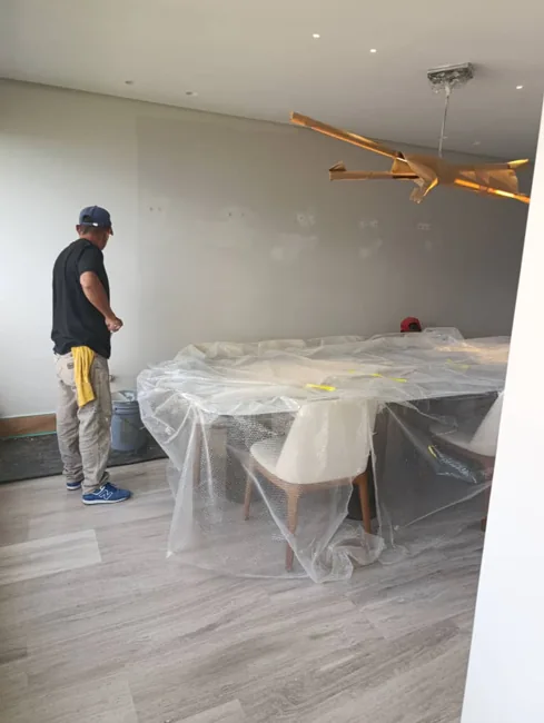Trabajo de pintura interior con mobiliario protegido