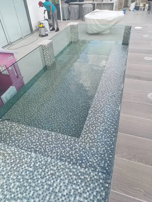 Detalle de mosaicos y cerramiento de vidrio en piscina
