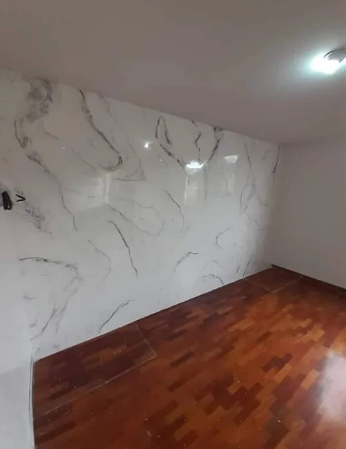 Pared con diseño de vetas grises junto a piso de madera