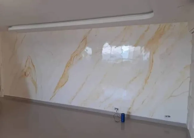 Revestimiento claro con vetas doradas e iluminación superior