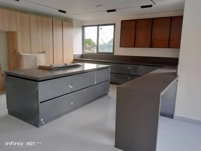 Instalación de cocina con isla gris y módulos de madera