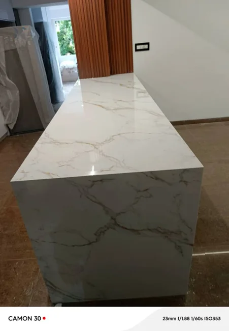 Detalle de encimera e isla con diseño de vetas doradas